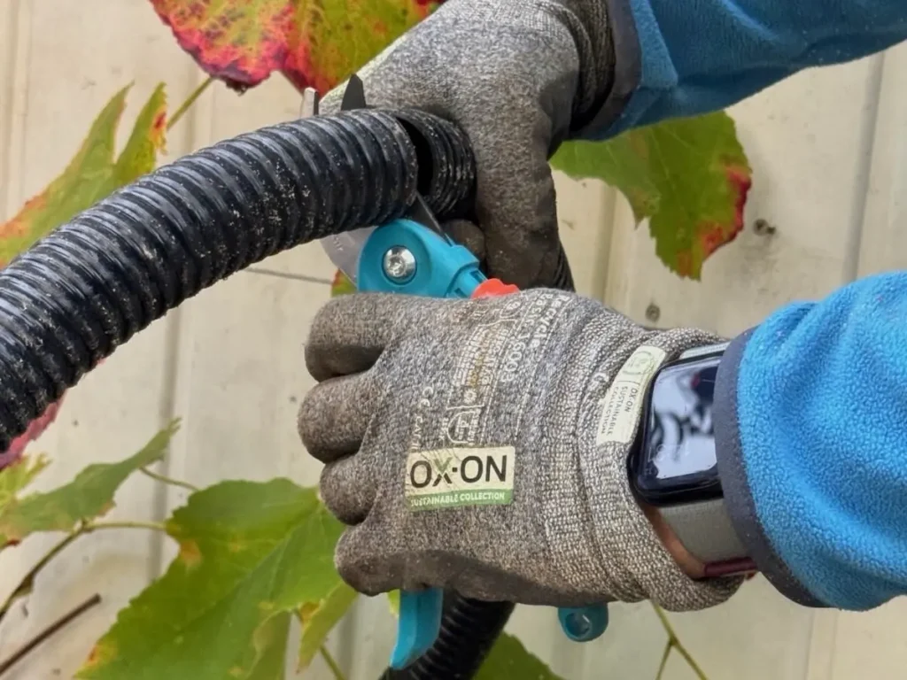 Zurechtschneiden eines PVC-Schlauchs mit Gartenschere für den Mini-Teich