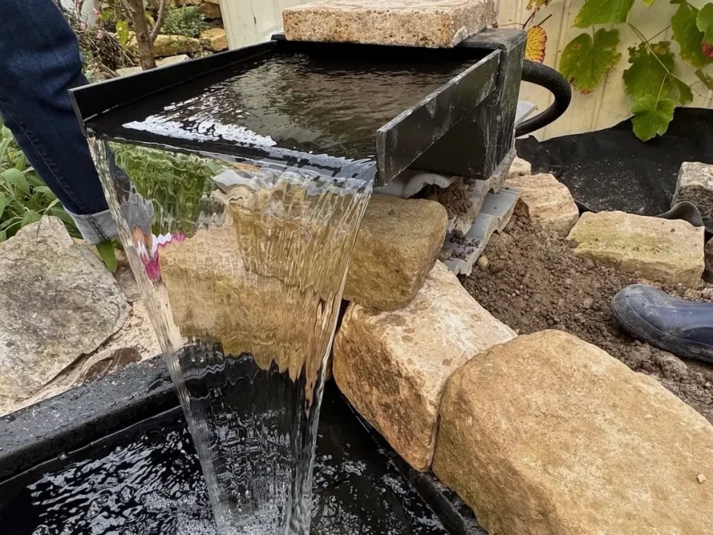 Angeschalteter Wasserfall auf einer Natursteinmauer