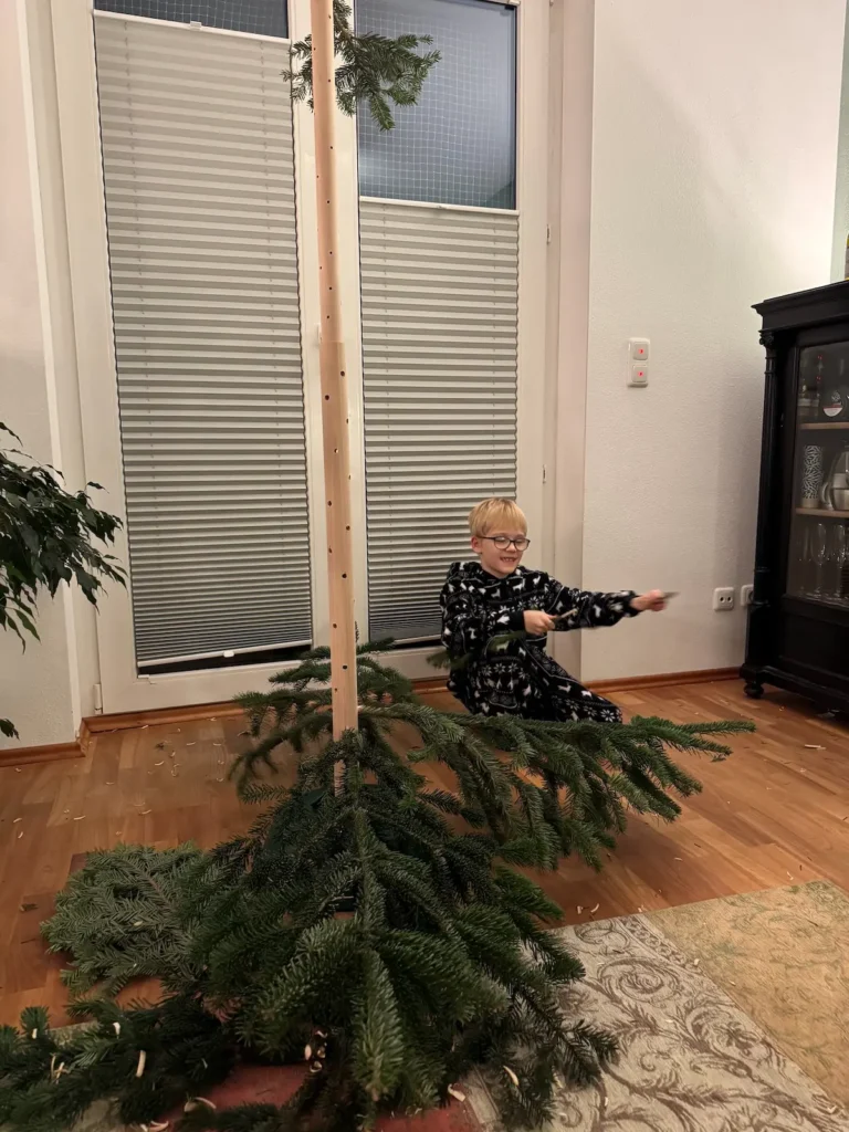 Aufbau eines Christbaums aus Holzstange und einzelnen Tannenzweigen