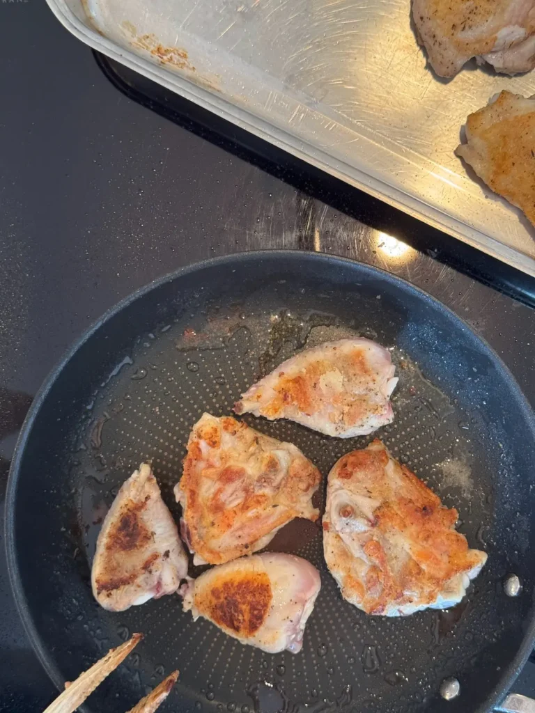 Goldbraun gebratene Hähnchenteile in einer Bratpfanne