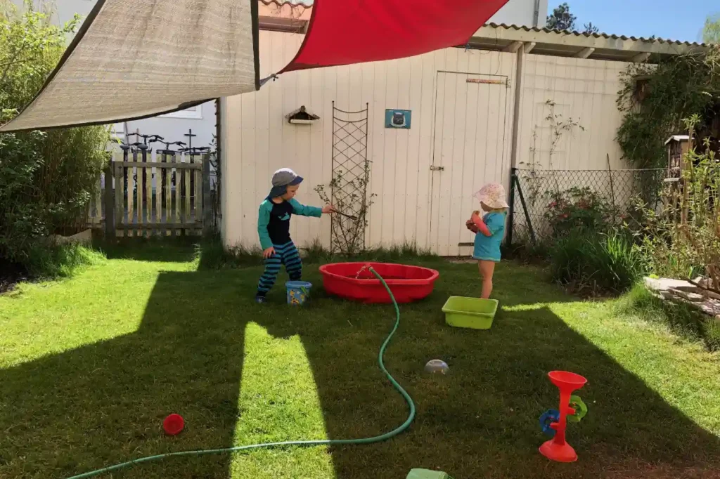 Kleiner garten mit wenig Pflanzen wo zwei Kinder spielen