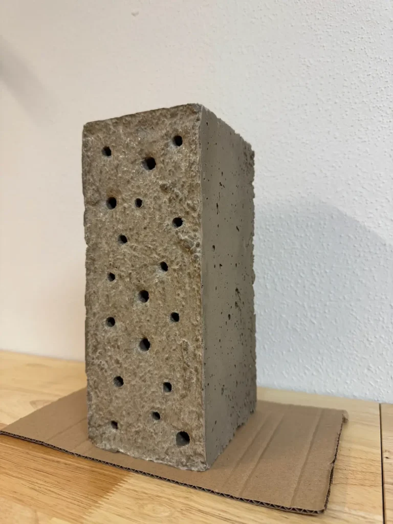 Niststein aus Beton mit verschieden großen Löchern.